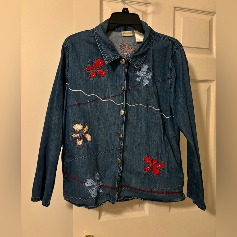 Denim jacket with flower appliqués& on seam pockets.